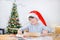 Cute child is rolling dough with Christmas tree behind