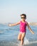 Cute child running in the waves at seaside