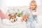 Cute child sitting on bed with pembroke welsh corgi dogs and holding bowl