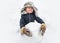 Cute child standing in winter hat with red nose. Joyful kid Having Fun and making snowman in Winter Park. Winter clothes