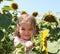 Cute child with sunflower in summer field