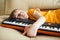 Cute child tired of learning to play the synthesizer. Kids hobbies and leisure. Future profession