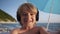 Cute child video chats on smart phone on beach