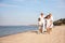 Cute children with grandparents spending time together on sea beach