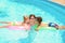 Cute children kissing their mother in swimming pool