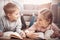 Cute children lying down on the floor and reading books