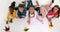 Cute children lying on floor drawing on paper and waving at camera