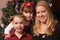 Cute Children and Mother Posing in Front Of Holiday Tree