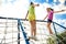 Cute children on playground rope climber outdoors. Summer camp