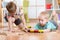 Cute children playing with wooden train. Toddler kids play with blocks and trains. Boys building toy railroad at home or