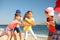 Cute children pulling rope during tug of war game on beach. Summer camp