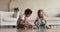 Cute children sit on floor at home play wooden cubes