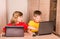 Cute children using laptops at home. Education, school, technology and internet concept - little students with laptop pc.