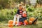 Cute childresn sitting on a garden near many pumpkins