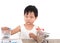 Cute Chinese little girl in a small shopping cart with dollar coins on the play table and financial information