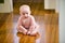 Cute chubby baby wearing diaper sitting on floor