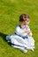 Cute chubby toddler looking at dandelion seeds curiously exploring nature outdoors in the park