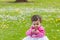 Cute chubby toddler looking at a leaf curiously exploring nature outdoors in the park