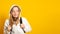 Cute cool schoolgirl dressed white hoodie on yellow  background with backpack looking away. Banner