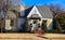 Cute cottage with yellow shutters and Christmas wreath and garland decorating entrance