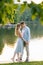 Cute couple in love, closing their eyes and touching their foreheads while walking near the lake having a vacation. Romantic guy a