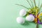 Cute creative Easter composition with white eggs, willow sprigs and colorful ribbons on green background. DIY and kids creativity
