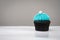 Cute cupcake with small white snow blue cream on white background