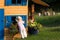 Cute curios girl looking into wooden playhouse in the garden