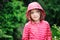 Cute curly child girl close up portrait in rainy summer garden