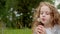 Cute curly girl blowing dandelion