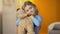 Cute curly-haired blond girl hugging teddy bear and smiling to camera, happiness