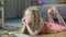 Cute curly-haired girl lying on soft carpet at home and smiling, happy child