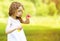 Cute curly little girl blowing soap bubbles outdoors