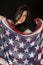 Cute dark complected woman holding an American flag scarf smiling
