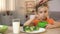 Cute daughter eating breakfast cereal with milk, mother stroking girl head