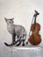 Cute devon rex cat and violin with bow on vintage chair. C