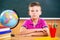 Cute diligent boy sitting in classroom