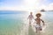 Cute diverse boy and little girl running and splashing together in the Caribbean ocea