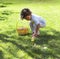 Cute diverse little boy collecting Easter eggs outdoors during an Easter Egg hunt