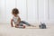 Cute diverse little boy playing with a toy train set in his home