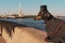 A cute dog of dachshund breed, black and tan, dressed in a suit and a top hat, on a walk on the embankment of St. Petersburg, Russ