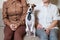 A cute dog Jack Russell Terrier is wearing a tie and sitting with two women on the couch