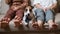 A cute dog Jack Russell Terrier is wearing a tie and sitting with two women on the couch