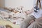 A cute dog lying in bed next to a human and looking directly at the camera. White borzoi, Russian greyhound puppy and a person