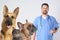 Cute dogs with cat and mature veterinarian on background