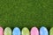 Cute Easter image with green grass as a background and sparkly colored eggs as a lower border.