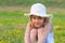 Cute elegant little girl sitting on the meadow