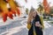 Cute emotional attractive blonde woman in coat with smartphone walks the city street. communication during the walk, lifestyle,