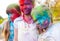 Cute european child girls celebrate Indian holi festival with colorful paint powder on faces and body