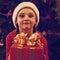 Cute excited kid girl in Christmas santa claus hat holding the r